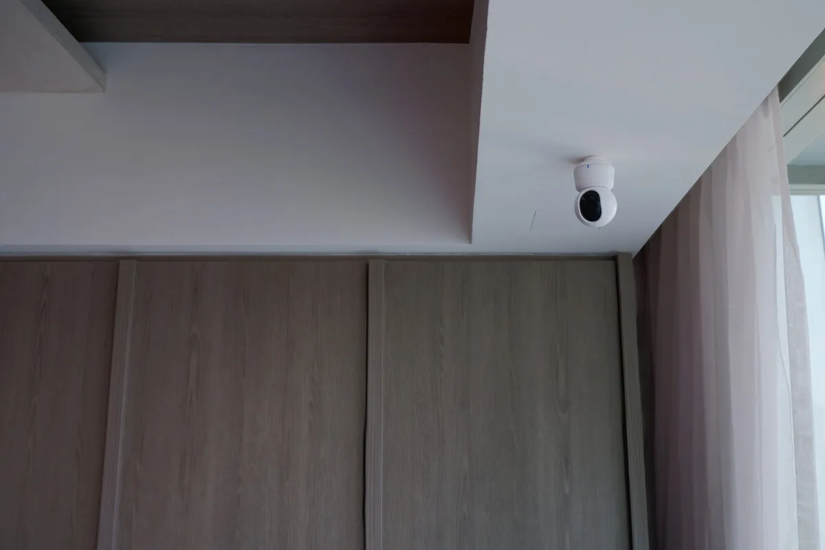 Indoor camera mounted at the ceiling above timber cabinetry