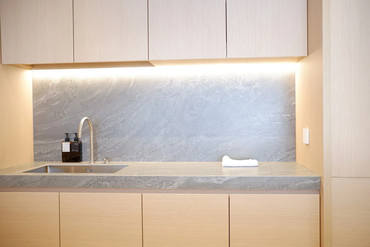 Under-cabinet lighting above a stone kitchen worktop