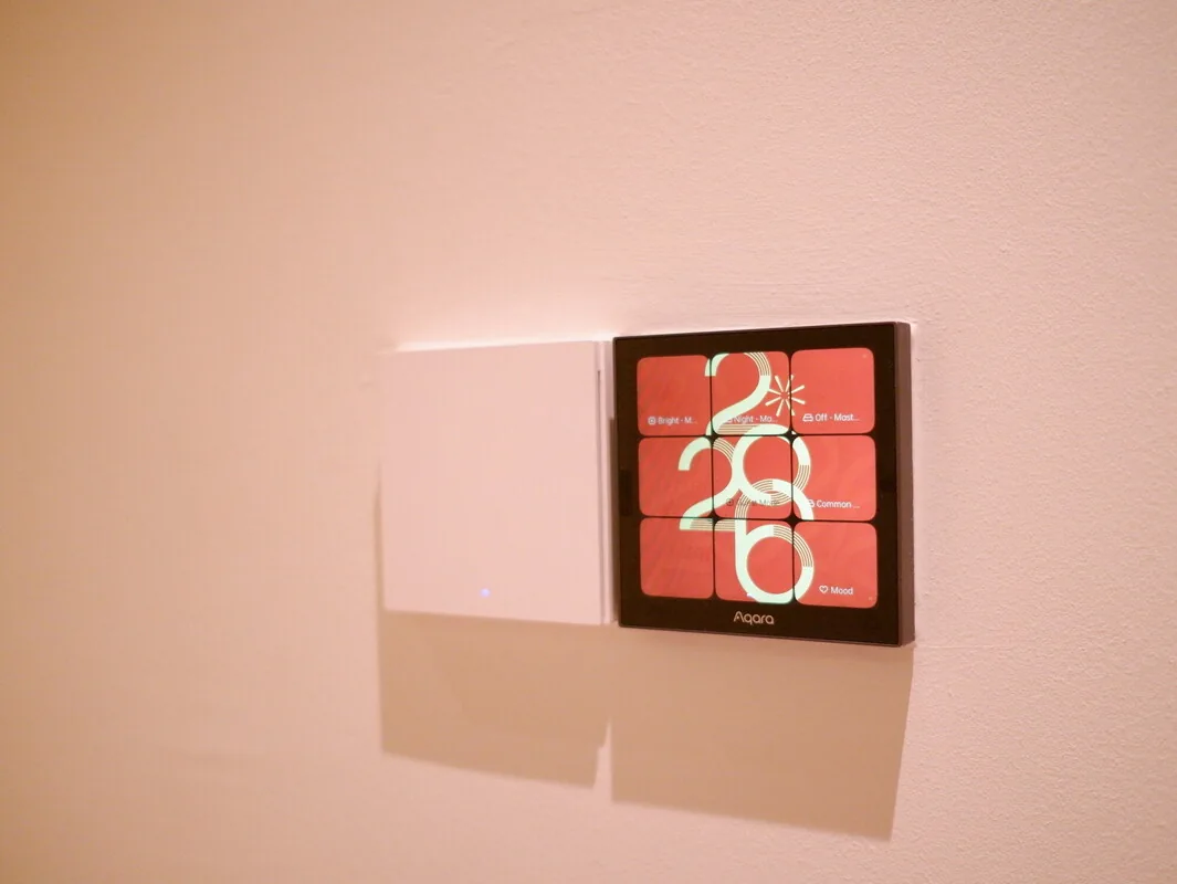 Wall-mounted scene display beside white switches