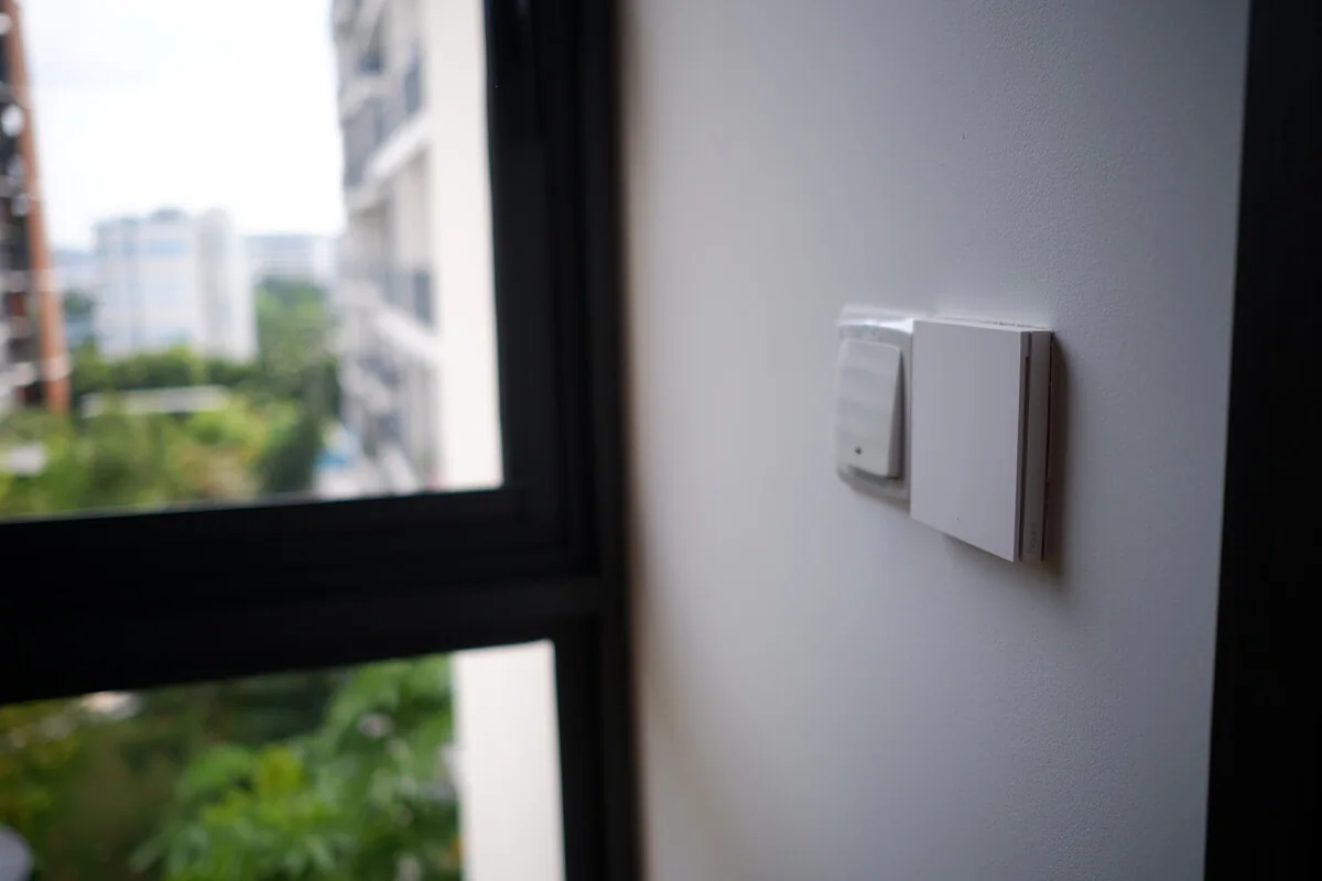 Compact wall controls beside a sunlit window